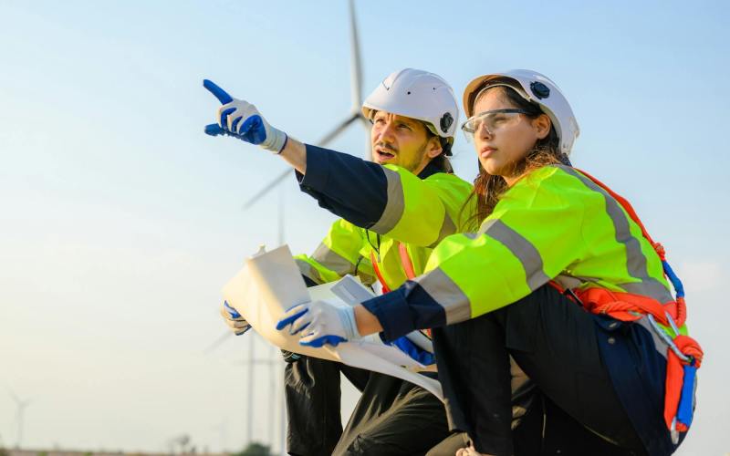 Engineer technician with safety uniform working at wind turbine field